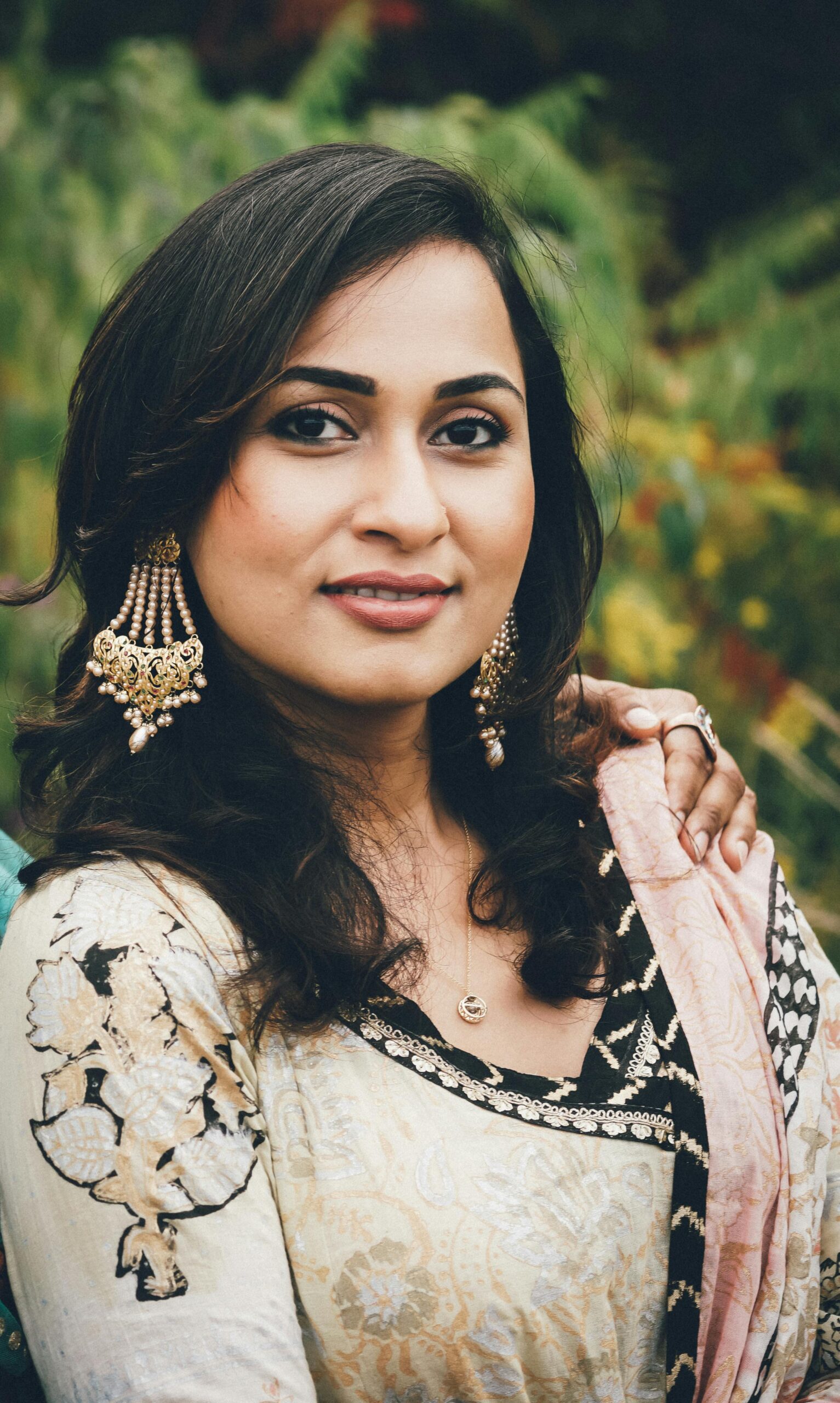 Portrait of a woman in traditional dress with earrings and necklace. Outdoors in autumn.