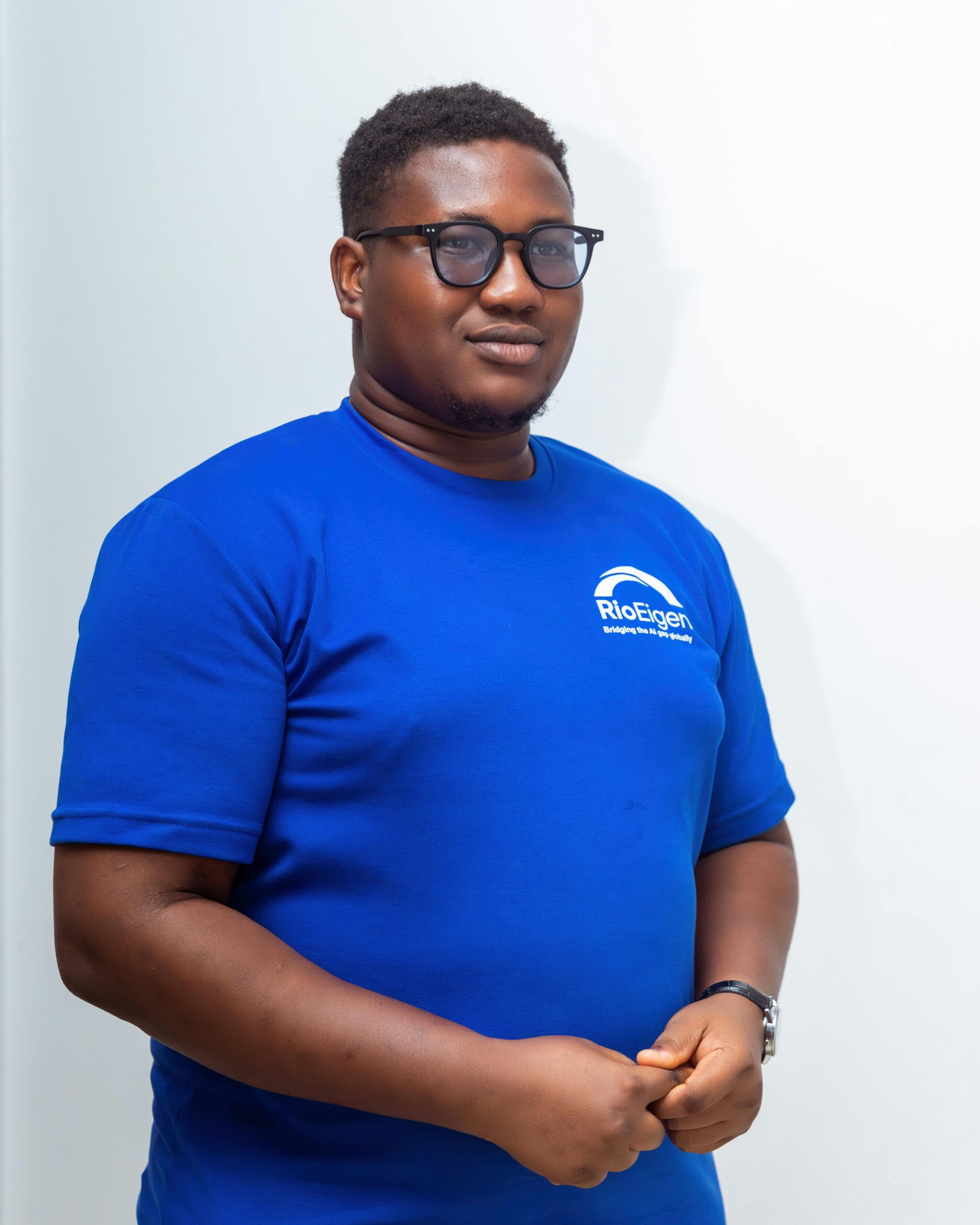 Confident man wearing a blue t-shirt with branding, standing indoors.